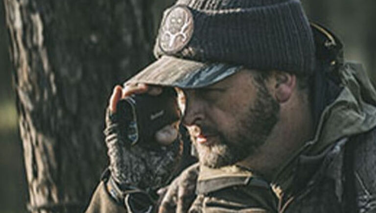 The Hunter's Guide To Archery Rangefinders And Binoculars Article Bone Collector Micheal Waddell looking through Bushnell Rangefinder