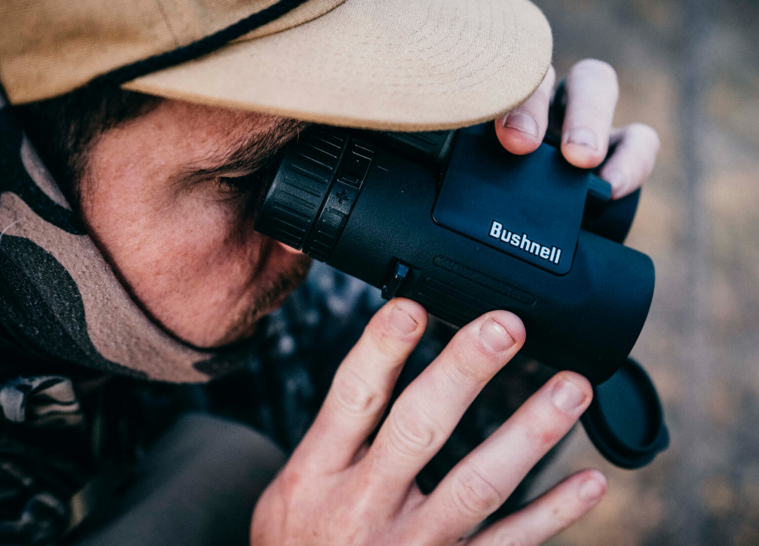 Bushnell Deals Close-up of man in the woods looking through Bushnell Binoculars