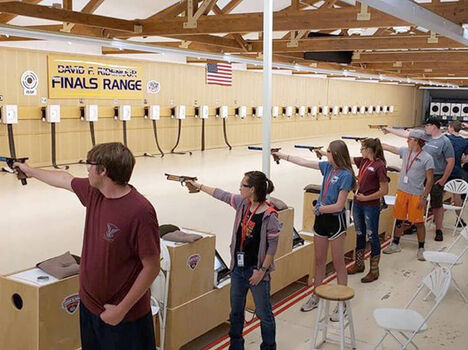 Young adults learning proper shooting at a range Young adults learning proper shooting at a range